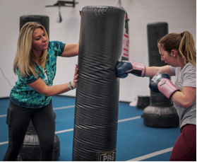 A TBS coach giving personal attention during kickboxing training
